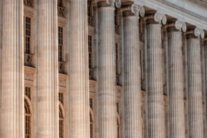 zoomed in photo of beige stone pillars on a courthouse front facade