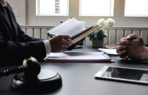 close-up lawyer showing a passage out of a book to a person crossing folding their fingers